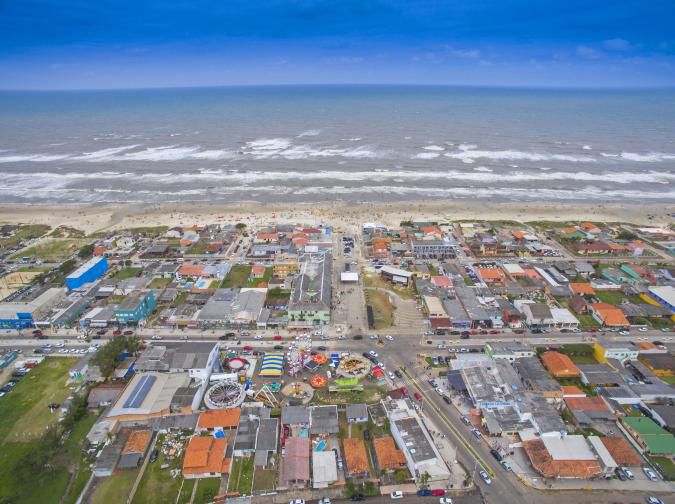 Vista aérea da orla e do centro de Balneário Pinhal, com o mar ao fundo
